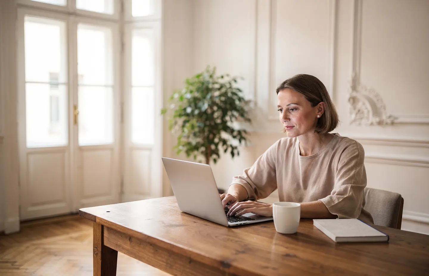 Selbstständige arbeitet in einem Wiener Altbaubüro am Laptop – Rechnungen schreiben in Österreich mit dem passenden Rechnungsprogramm