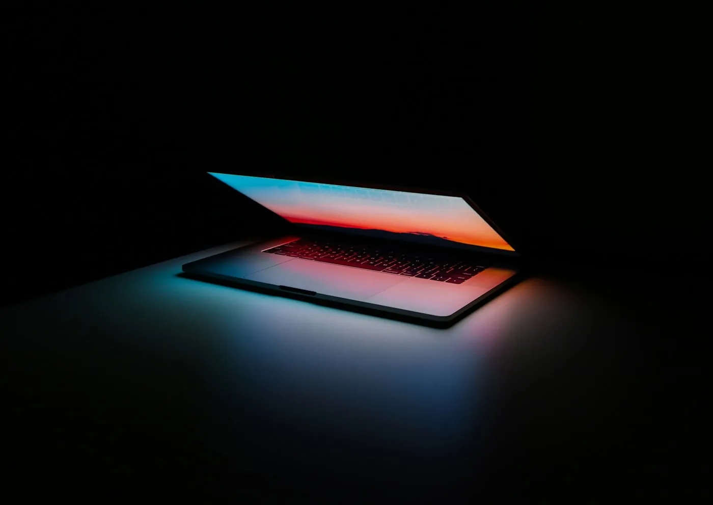 Laptop mit leuchtendem Bildschirm im Dunkeln – ZUGFeRD und EN16931-konforme E-Rechnung automatisch im Hintergrund erzeugen