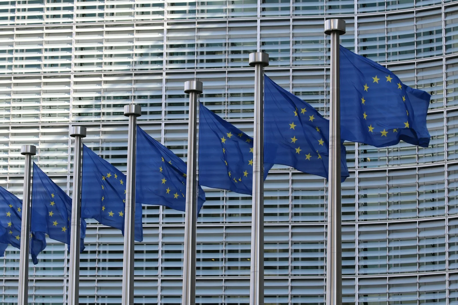 Europafahnen vor einem EU-Gebäude in Brüssel – ViDA-Reform bringt ab 1. Juli 2030 die E-Rechnungspflicht für grenzüberschreitende B2B-Umsätze in der EU