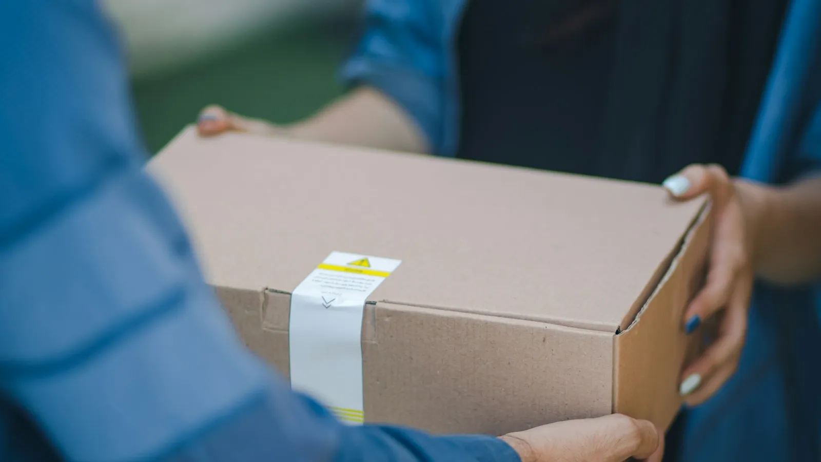 Kundin übergibt ein Paket zurück an den Händler, typischer Anlass für eine kaufmännische Gutschrift als Rechnungskorrektur nach einer Rücksendung